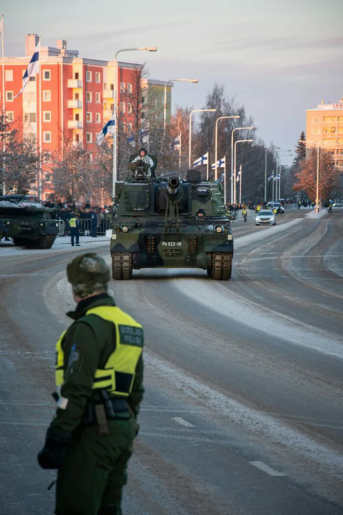 Military tanks parade on a snowy street, showing potential misunderstandings between locals and foreigners.